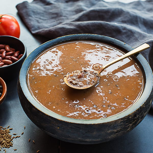 A bowl of Kasa Indian Eatery's Dal Makhani, a rich lentil dish, with a spoon.